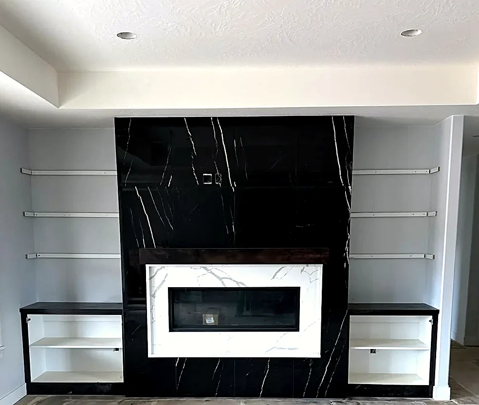 Floor-to-ceiling black marble fireplace surround with a white marble inset and a floating timber mantel