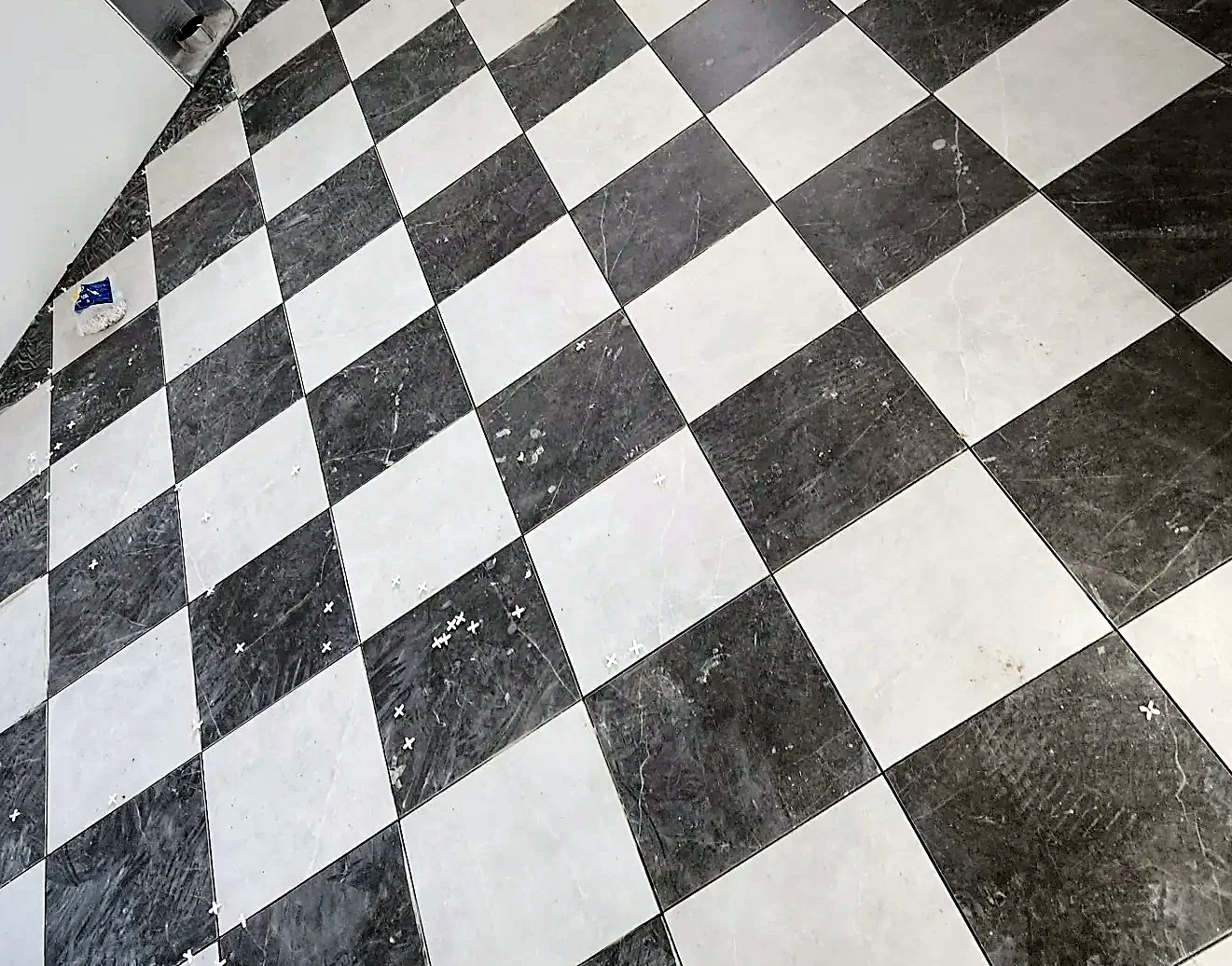 Close view of the marble checkerboard floor showing consistent grout width across every joint
