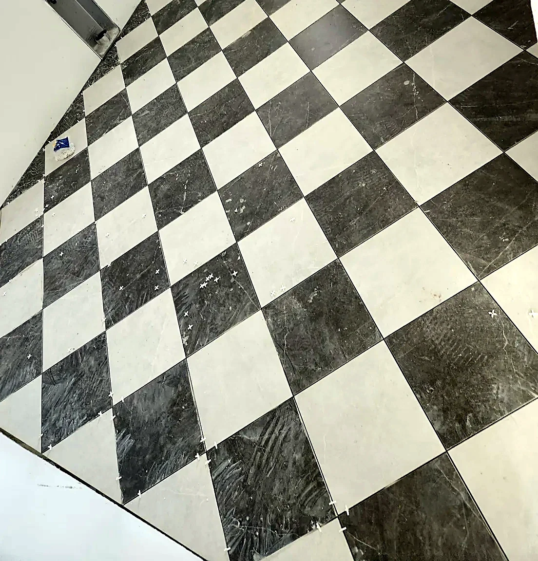 Black and white marble checkerboard floor set on the diagonal across a full room