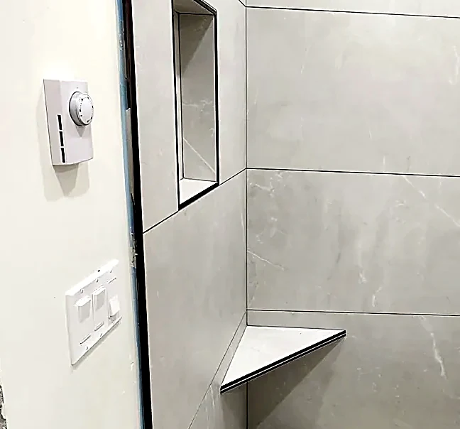 A folded corner bench — the wall tile carries around the return without a break